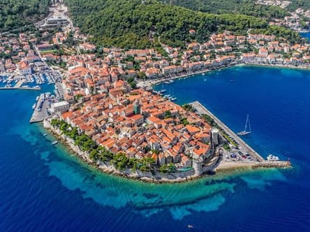 Korčula town by boat from Dubrovnik — walled old town on its peninsula with the Pelješac channel behind