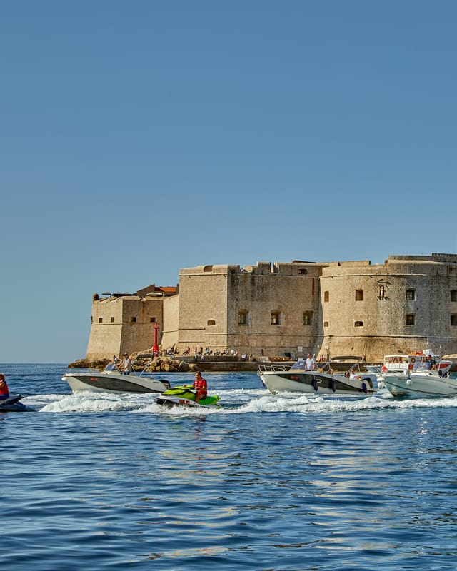 Boats and jet skis of the Rent Boat Dubrovnik fleet in front of the Dubrovnik old town walls